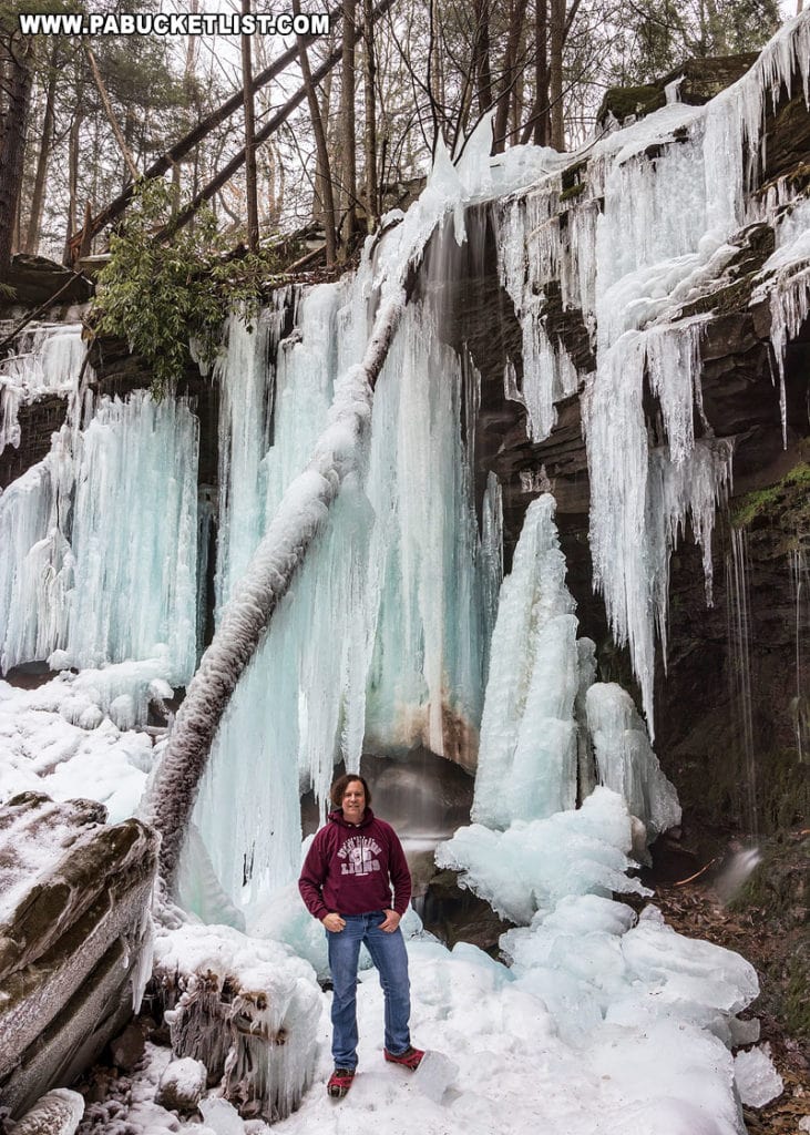 Rusty Glessner standing next to ice formations at Jacoby Falls.