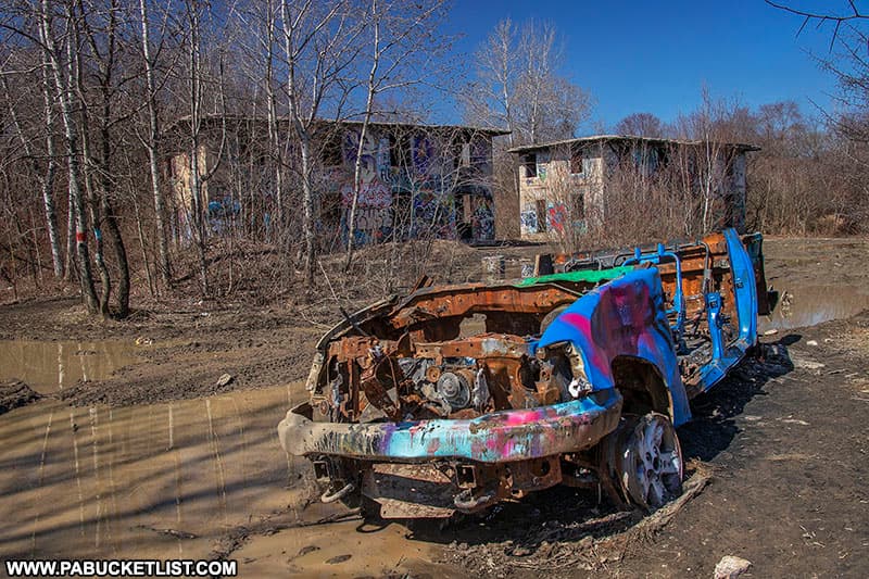 A burned-out truck resting on a road in Concrete City.