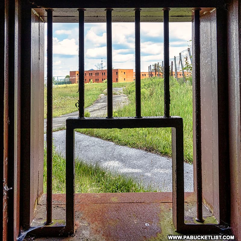 Looking out a barred window at the abandoned Cresson State Prison.