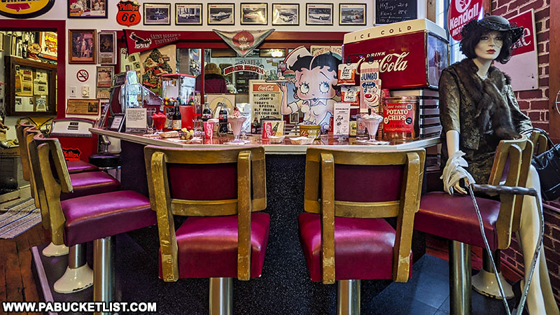 A soda fountain counter is reproduced in this scene from Jerry's Classic Cars and Collectibles Museum in Pottsville.