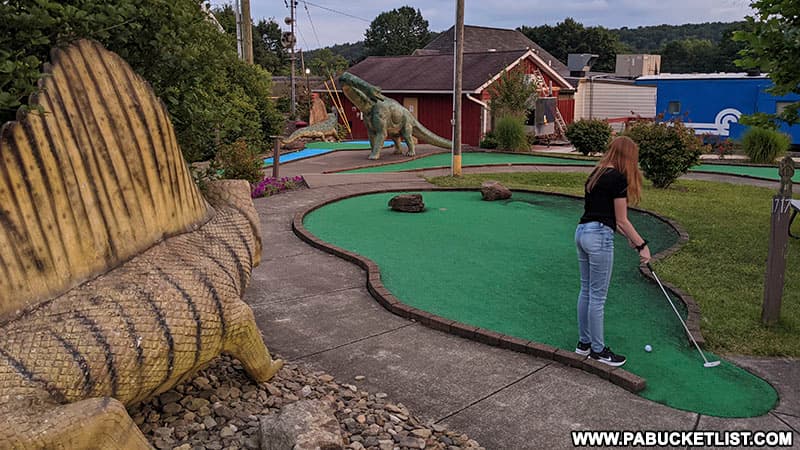 My daughter putting at the dinosaur-themed Doolittle Station mini golf course. in Clearfield.