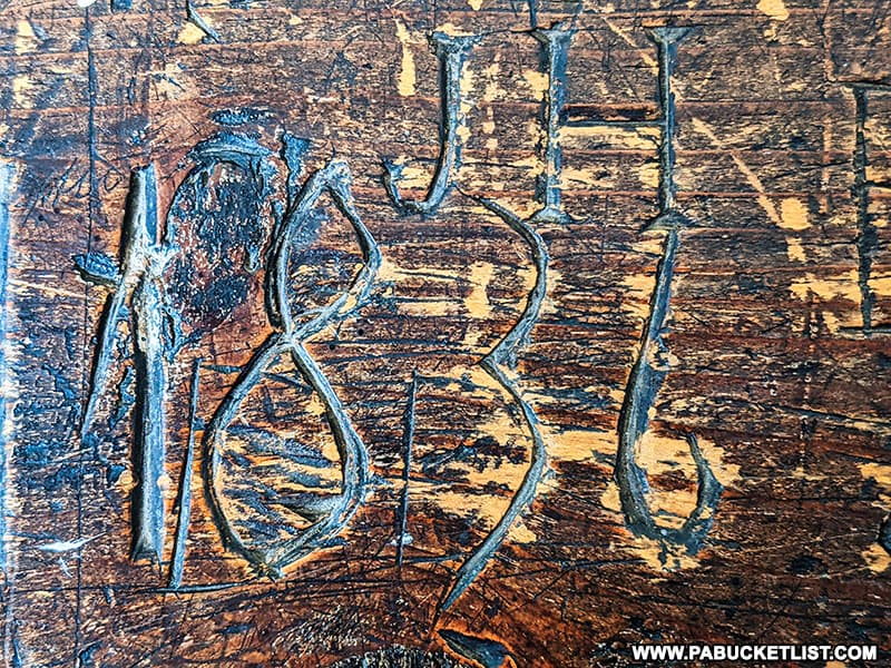 Carving in a pew at the 1806 Old Log Church from 1836.