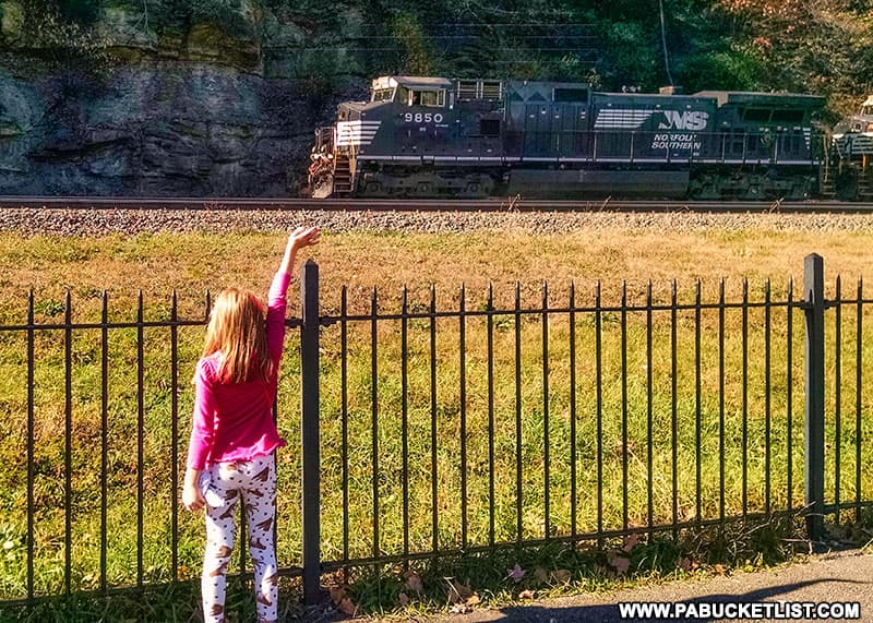 A young railfan waves to a passin Norfolk Southern engineer at the Horseshoe Curve.