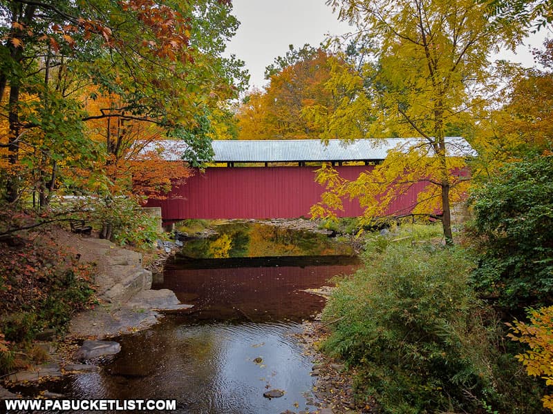 A side view of the New Baltimore Covered Bridge during the peak of fall foliage season.