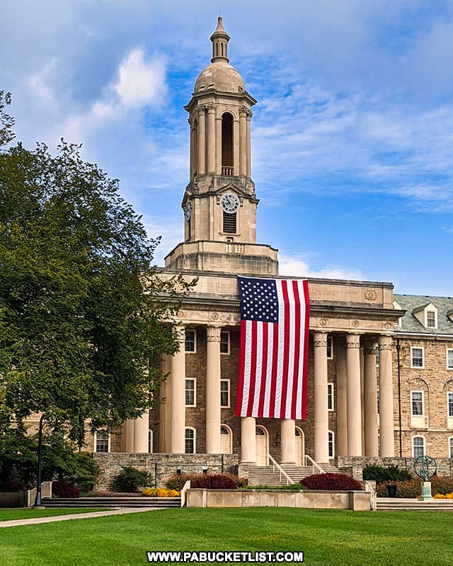 The Stars and Stripes hanging from the pillars of Old Main at Penn State.