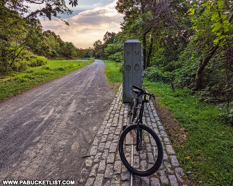 A bicycle straddling the Mason-Dixon Line along the Great Allegheny Passage at the Mason and Dixon Line Park.