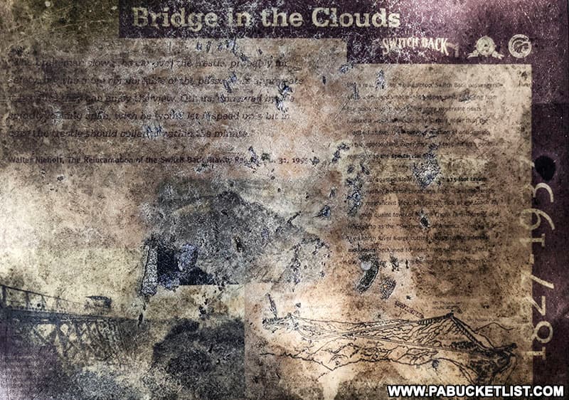 A weathered historical sign about the "bridge in the clouds" along the Switch Back Railroad.