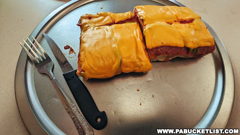 Altoona-style pizza served with a knife and fork, similar to an open-faced sandwich.