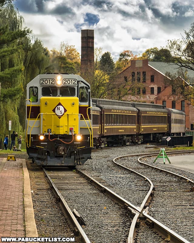 A fall foliage train excursion returning to the Bellefonte Train Station at Talleyrand Park.