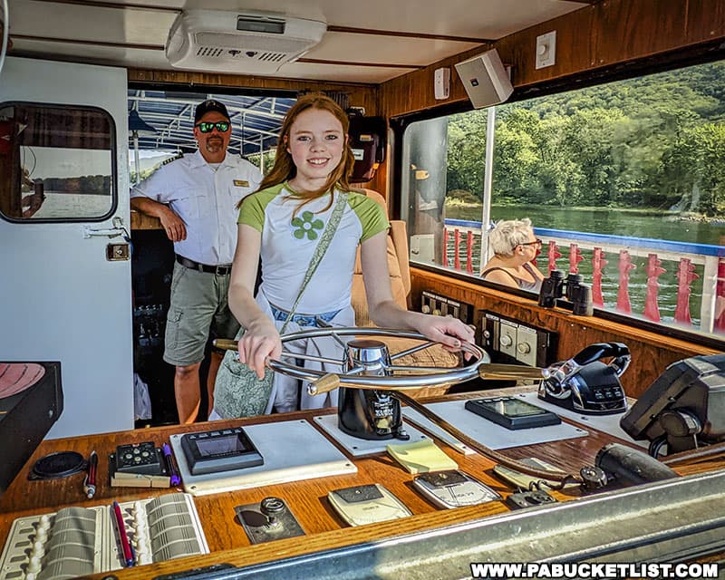 Taking the wheel of the Hiawatha riverboat, with the Captain's permission.