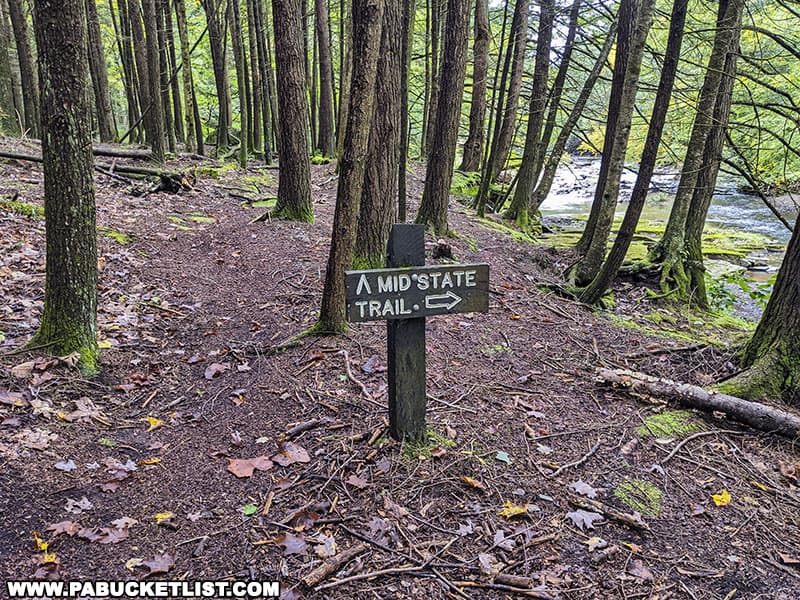 Mid State Trail sign near the wet crossing over Stony Fork just downstream from the Big Falls swimming hole in Tioga County Pennsylvania.