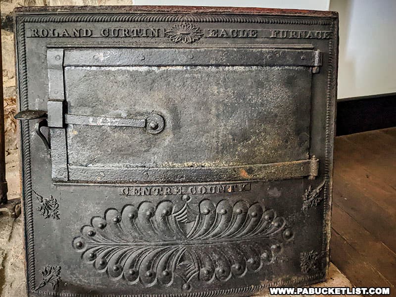 An original stove door stamped Roland Curtin Eagle Furnace inside the Curtin Mansion.
