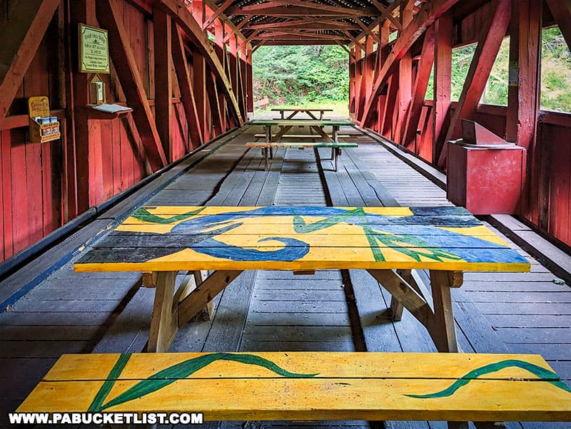 The picnic tables inside the Josiah Hess Covered Bridge feature murals like the tables in the nearby Twin Bridges.