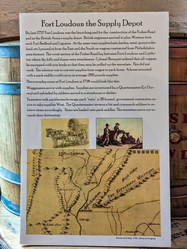 Informational display titled 'Fort Loudoun the Supply Depot' detailing the history of the fort as a supply depot in 1757. The text describes logistics and supply methods of the era. Accompanying the text are two illustrations: one of a horse-drawn cart and another of a historic map labeled 'Nichols Scull Map 1759, Library of Congress'. Display set against a rustic wooden background at Fort Loudoun in Franklin County, Pennsylvania.