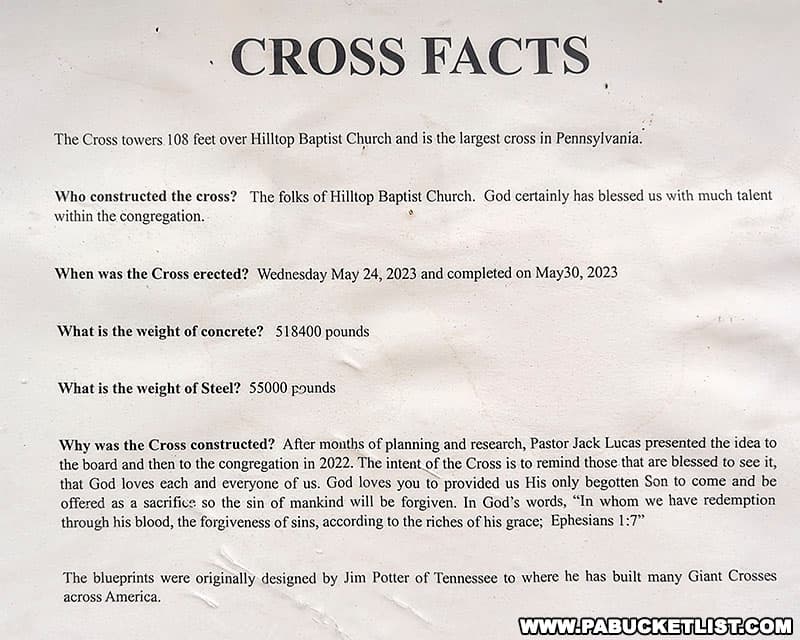 A fact sheet about The Cross is posted at a kiosk near its base.