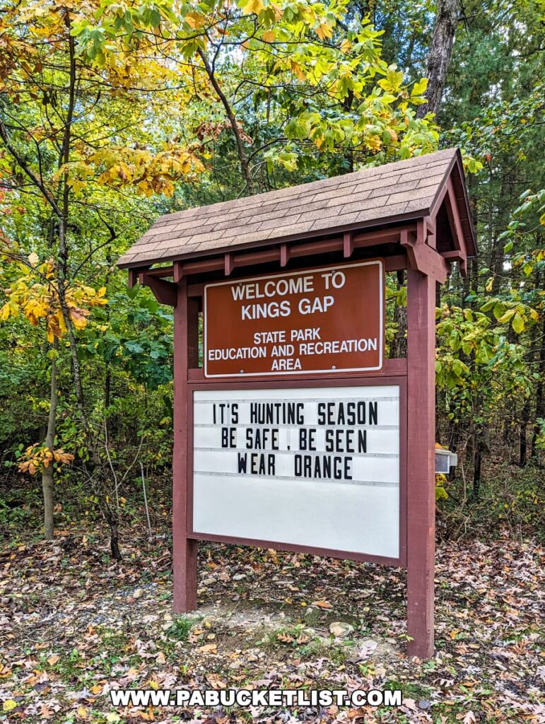 Welcome sign at Kings Gap State Park near Cameron-Masland Mansion, advising safety during hunting season with fall foliage backdrop.