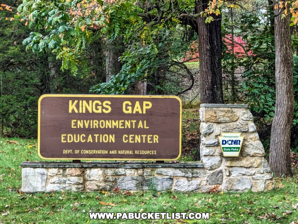 Sign for Kings Gap Environmental Education Center with autumn trees, part of Pennsylvania's conservation and natural resources.