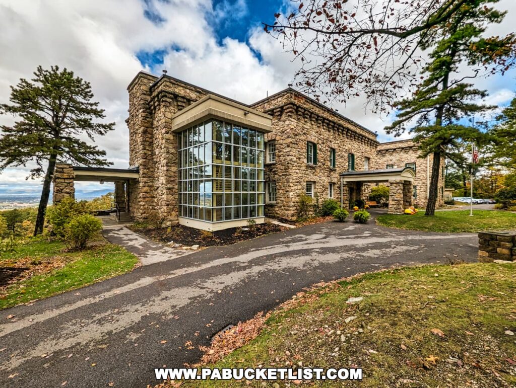 Side view of Cameron-Masland Mansion with glass conservatory, stone architecture, and panoramic view of Cumberland Valley, PA.