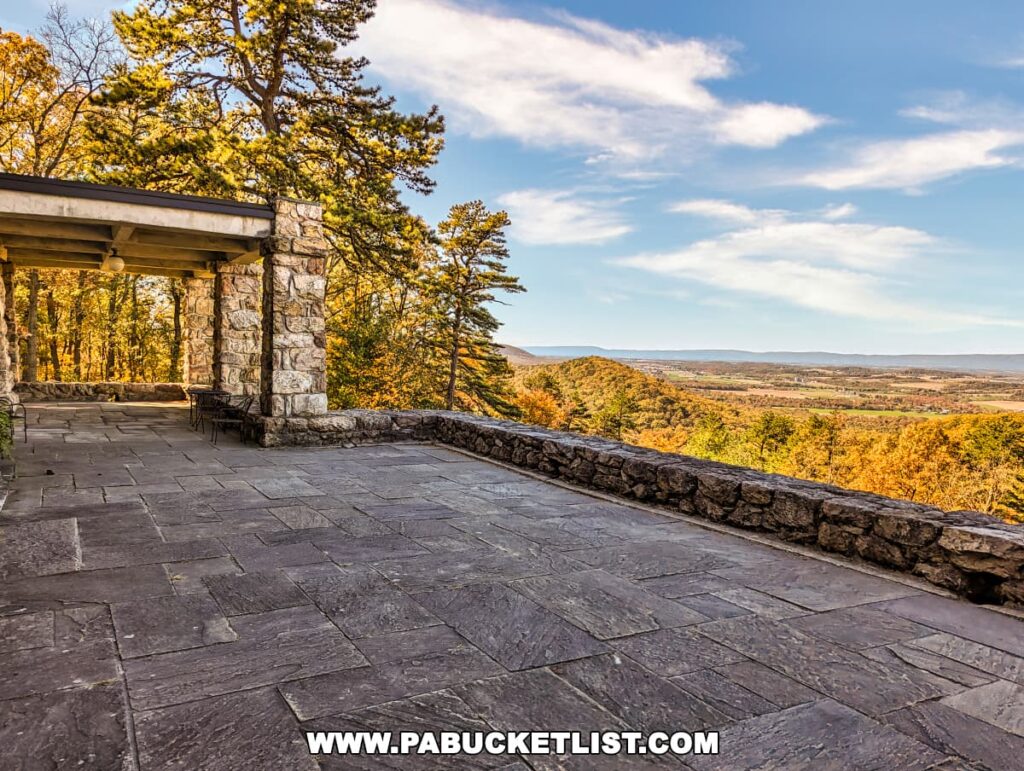 Terrace at Cameron-Masland Mansion with a stone patio and wall overlooking the colorful Cumberland Valley during fall in Pennsylvania.