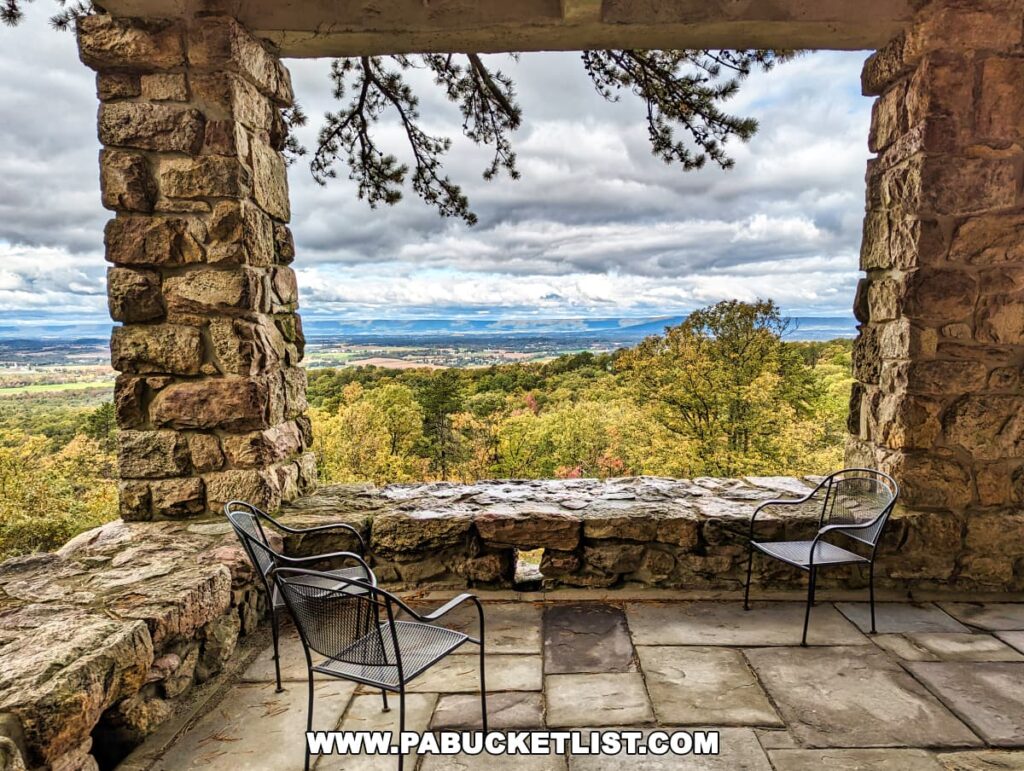 Scenic view from a stone terrace with seating at Cameron-Masland Mansion, overlooking the vast Cumberland Valley and a dramatic sky.