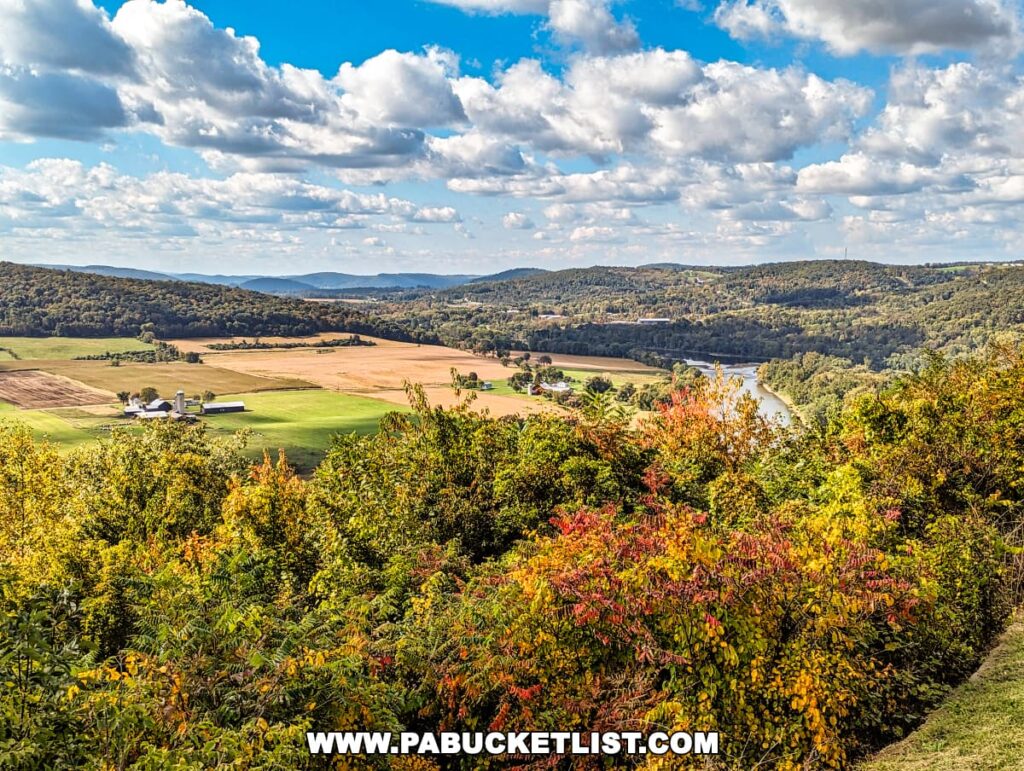 Expansive view from the Marie Antoinette Scenic Overlook in Bradford County, Pennsylvania. The vista includes a colorful mosaic of autumn foliage in the foreground, with a mix of green, yellow, orange, and red leaves.