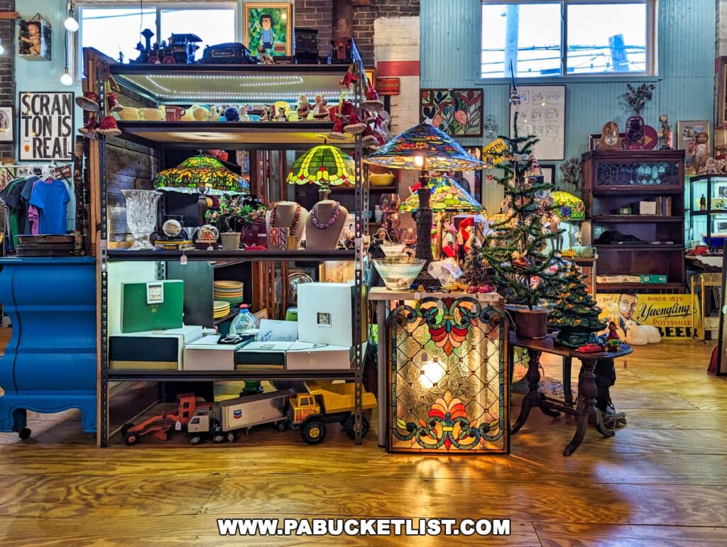 Inside the On and On Vintage Marketplace in Scranton, Pennsylvania, showcasing an eclectic array of vintage items. The shelves are filled with colorful stained glass lamps, a decorated Christmas tree, and a variety of collectibles. Vintage toys, a sign saying 'SCRANTON IS REAL', and a 'Yuengling Beer' advertisement contribute to the nostalgic atmosphere. Large windows allow natural light to illuminate the wooden floors and the diverse assortment of antiques.