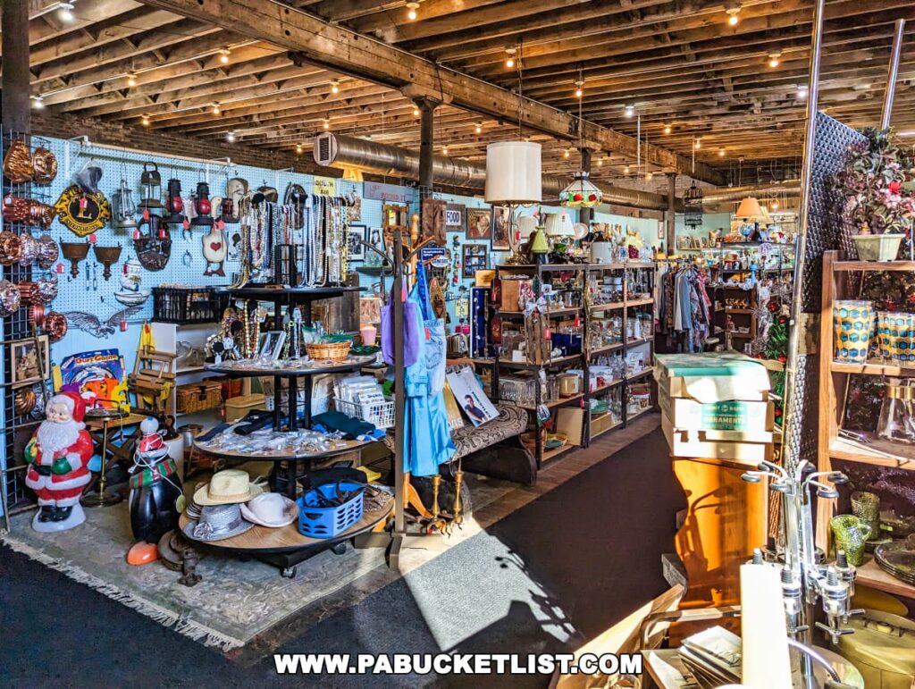 An interior view of the On and On Vintage Marketplace displaying an eclectic mix of items. A pegboard wall is adorned with various kitchen utensils and decorative objects, while the central space features tables with vintage clothing, hats, and jewelry. A Santa figure, a child's ride-on toy, and a collection of lamps can also be seen. The store's rustic charm is highlighted by the wooden ceiling beams above. Natural light streams in, casting shadows on the floor.