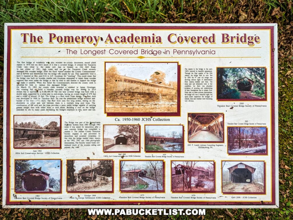 An informational sign titled 'The Pomeroy-Academia Covered Bridge - The Longest Covered Bridge in Pennsylvania,' featuring text and a collection of historical photographs. Images include various views of the bridge throughout the years, ranging from circa 1950 to 2003, depicting different seasons and the bridge's architecture. The sign includes detailed historical context and acknowledges the contributions of the Theodore Burr Covered Bridge Society of Pennsylvania.