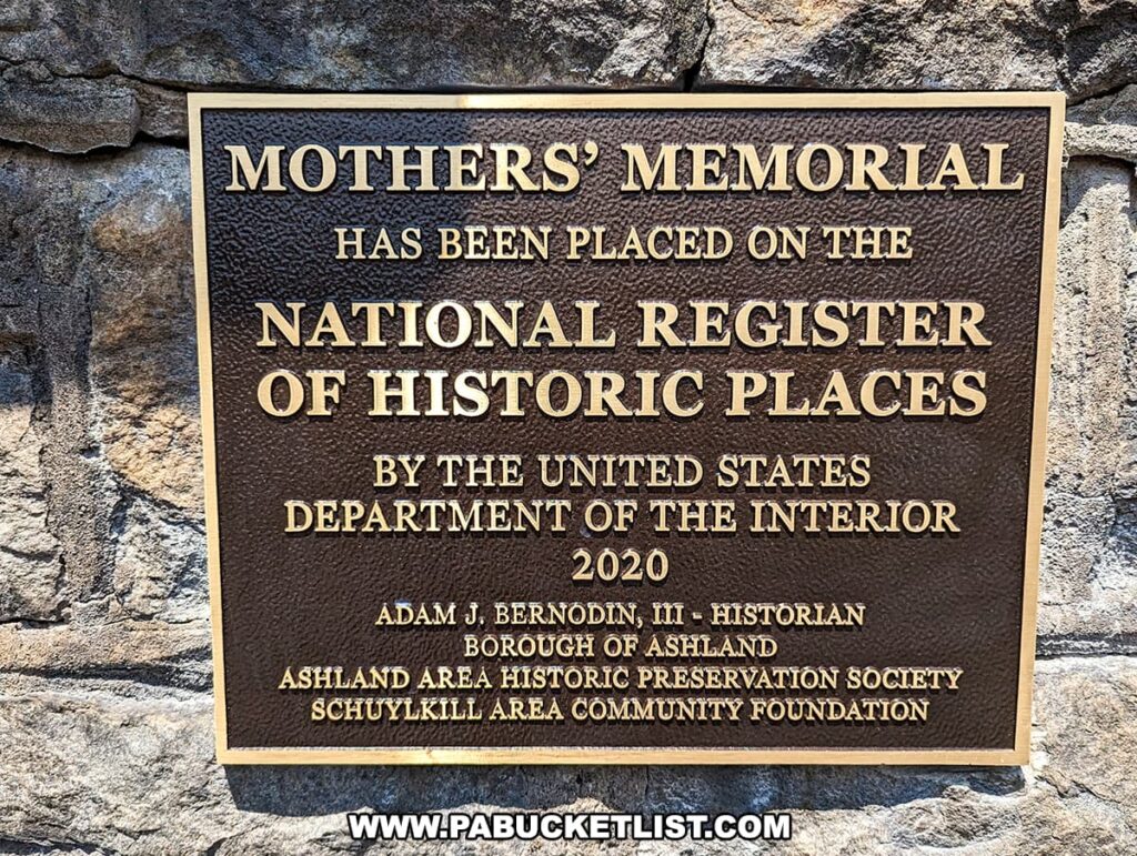 A plaque at the Ashland Mothers' Memorial in Ashland, Pennsylvania, indicating that the memorial has been placed on the National Register of Historic Places by the United States Department of the Interior in 2020. The plaque credits Adam J. Bernodin, III as the historian, along with the Borough of Ashland, Ashland Area Historic Preservation Society, and Schuylkill Area Community Foundation.
