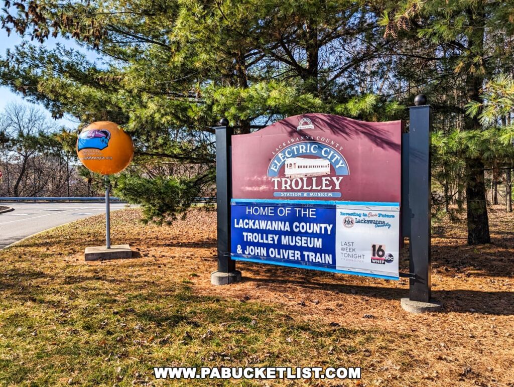 Entrance sign of the Electric City Trolley Museum in Scranton, Pennsylvania, with a large promotional globe and information about the museum's features on a bright sunny day.