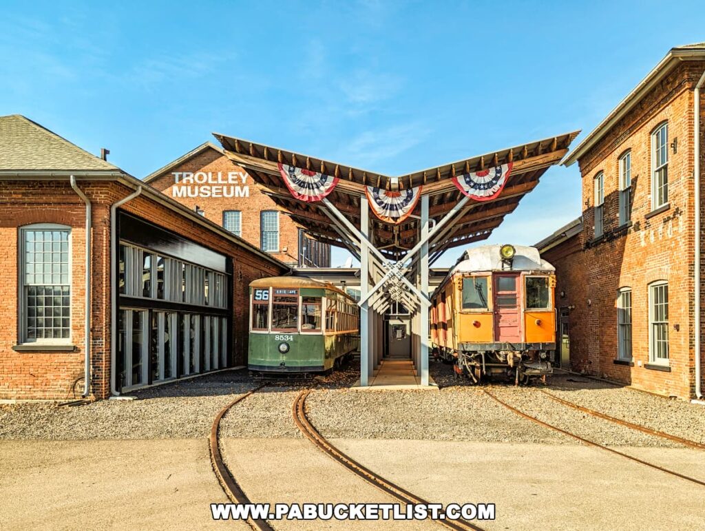 Outside view of the Electric City Trolley Museum in Scranton, Pennsylvania, with vintage trolleys on display, museum signage, and festive wreaths on a sunny day.