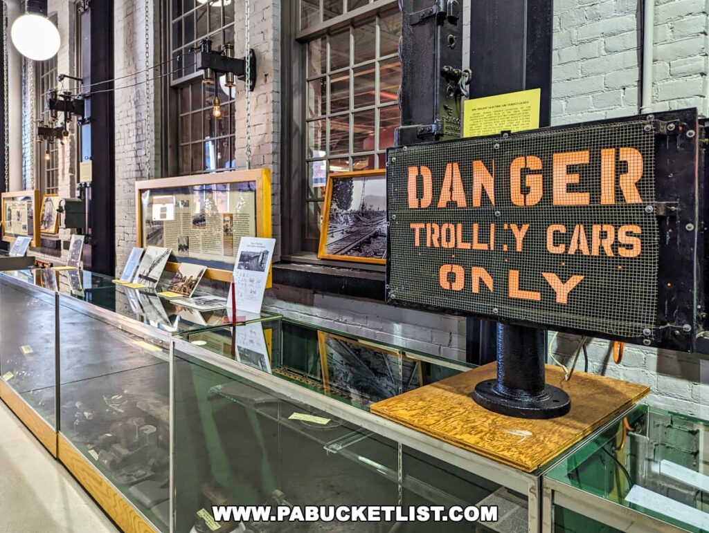 Interior of the Electric City Trolley Museum in Scranton, Pennsylvania, featuring a vintage 'DANGER TROLLEY CARS ONLY' sign, with historical photographs and artifacts on display in the background.