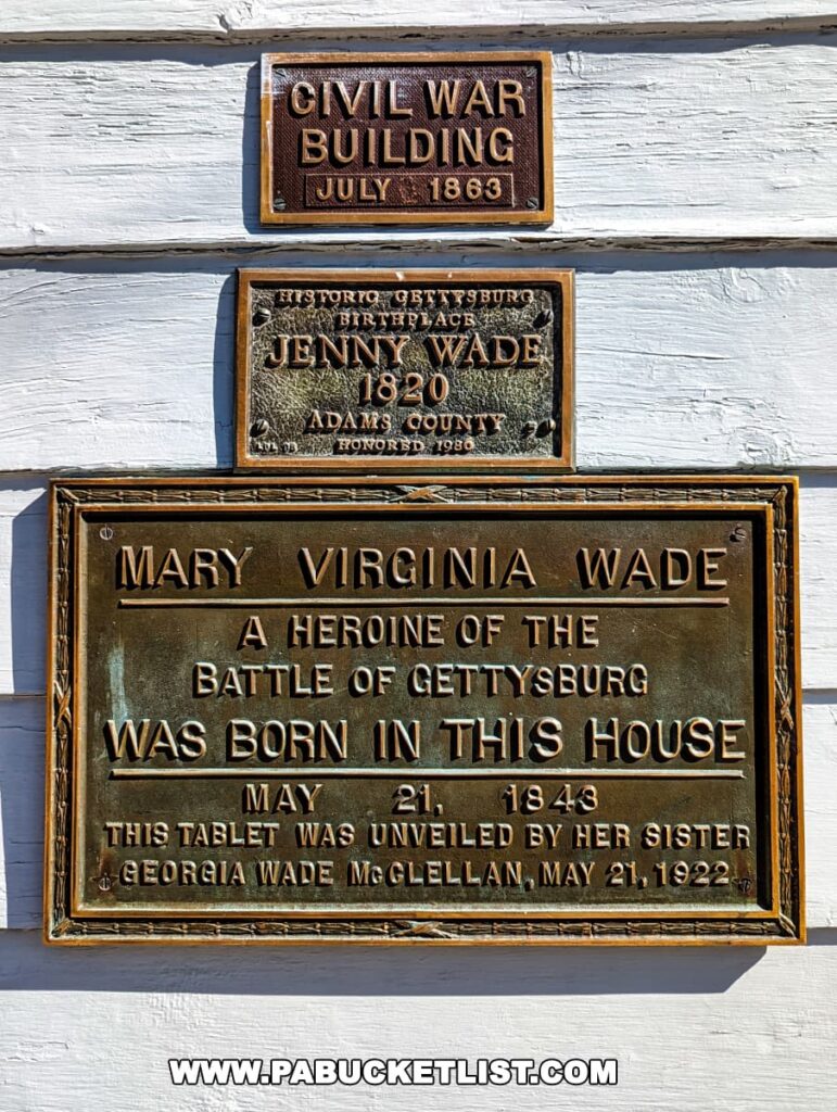 Two commemorative plaques on the exterior of Jennie Wade's birthplace in Gettysburg, Pennsylvania. The top plaque identifies the building as a Civil War building from July 1863. The larger plaque below states Mary Virginia Wade was a heroine of the Battle of Gettysburg, born in this house on May 21, 1843, and that the tablet was unveiled by her sister in 1922.