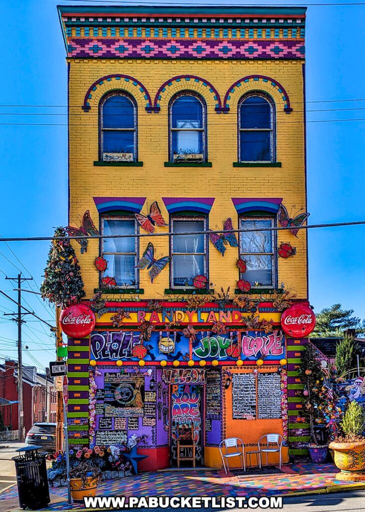 Colorful and eclectic entrance of Randyland with vibrant murals, whimsical decorations, and welcoming signs on Arch Street in Pittsburgh, Pennsylvania.