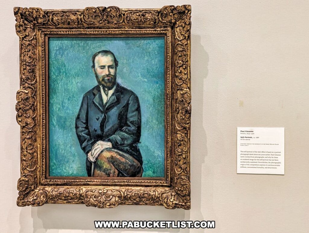 A painting titled 'Self-Portrait' by Paul Cézanne, circa 1885, on display at the Carnegie Museums of Art and Natural History in Pittsburgh, PA. The portrait, set within a highly ornate gold frame, features the artist seated, dressed in a dark suit against a vibrant teal background. The brushwork is expressive and textured, characteristic of Cézanne's style. To the right of the painting, an informational placard provides visitors with details about the artwork and its historical context.