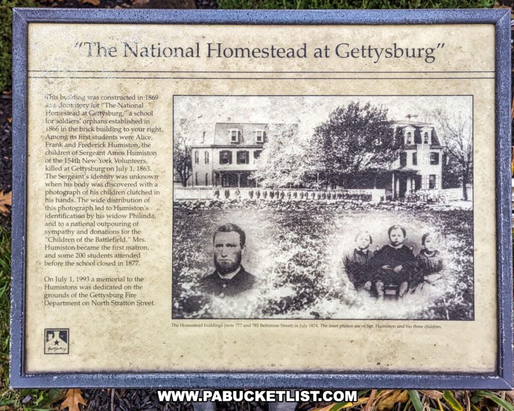 An informative plaque titled 'The National Homestead at Gettysburg' displayed at the Civil War Tails Diorama Museum in Gettysburg, PA. It details the history of the building that now houses the museum, originally constructed in 1869 as a dormitory for 'The National Homestead at Gettysburg,' a school for soldiers' orphans. The text includes the story of Sergeant Amos Humiston of the 154th New York Volunteers, who died at the Battle of Gettysburg and was identified through a photograph of his children found in his hands. A faded historical photograph of the homestead and a portrait of Sgt. Humiston with his three children accompany the text. The plaque commemorates the Homestead's past and the memorial dedicated to the Humistons in 1993.