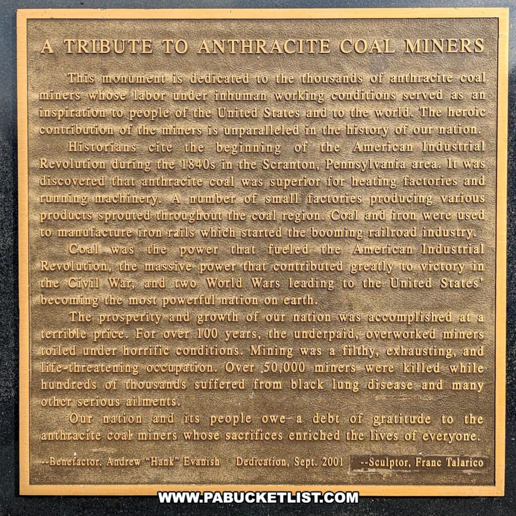 Close-up of a bronze memorial plaque titled 'A TRIBUTE TO ANTHRACITE COAL MINERS'. The plaque is dedicated to the thousands of anthracite coal miners and acknowledges their labor and sacrifices under inhumane conditions, contributing to the nation's prosperity and growth. It mentions the history of coal mining since the 1840s in Scranton, Pennsylvania, the use of coal and iron in the booming railroad industry, and the role of coal power in the American Industrial Revolution and both World Wars. The tribute also notes the harsh realities of mining, including over 50,000 miners killed and many suffering from black lung disease. The plaque ends with an acknowledgment of the debt owed to the miners and is signed by benefactor Andrew 'Hank' Evanish with a dedication date of September 2001, and sculptor Fran Talarico.