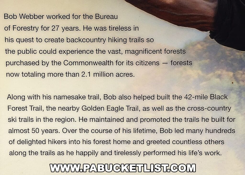 An excerpt from an informational display about Bob Webber, detailing his 27 years of work with the Bureau of Forestry and his dedication to creating backcountry hiking trails in the Commonwealth's forests, now over 2.1 million acres. It mentions his contribution to building the 42-mile Black Forest Trail, the nearby Golden Eagle Trail, and cross-country ski trails in the region. The text honors his commitment to maintaining and promoting these trails and warmly welcoming hikers into the forest for nearly 50 years.