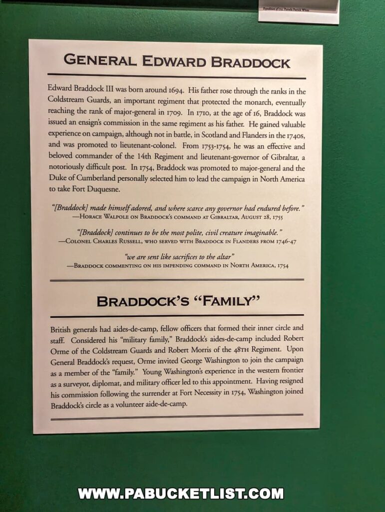 An informational exhibit at Braddock's Battlefield History Center detailing the biography of General Edward Braddock, including his early life, military career, and his role as a major-general in the Coldstream Guards. Below the biography, there's a section titled "Braddock's 'Family'", describing his military aides-de-camp and their close relationship, particularly mentioning George Washington as a volunteer aide-de-camp. The text is printed on white paper against a green background.