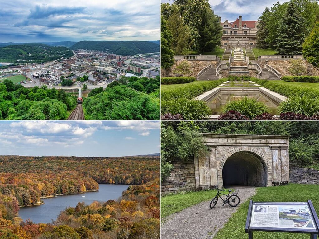 A collage of four photos highlighting points of interest in Cambria County, Pennsylvania. Top left: An expansive aerial view of a densely built town with multiple buildings, surrounded by green hills. Top right: A stately mansion with a cascading fountain in front, set against manicured lawns and a backdrop of trees. Bottom left: A sweeping landscape view of a river curving through a colorful, forested valley during fall. Bottom right: A historic stone railroad tunnel with a bicycle parked at its entrance and an interpretive sign in the foreground.