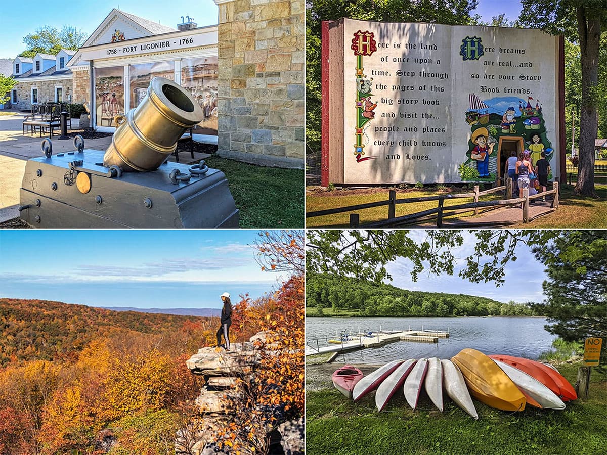 A collection of four photos depicting attractions in Westmoreland County, Pennsylvania. Top left: A large historic cannon displayed outside with the Fort Ligonier museum entrance in the background. Top right: A whimsical, large book-shaped mural with a fairy tale theme, inviting visitors to walk through to a park. Bottom left: A person stands on a rocky outcrop overlooking a stunning autumn forest vista. Bottom right: A lineup of colorful kayaks and canoes on the grassy shore of a tranquil lake with a dock in the background.