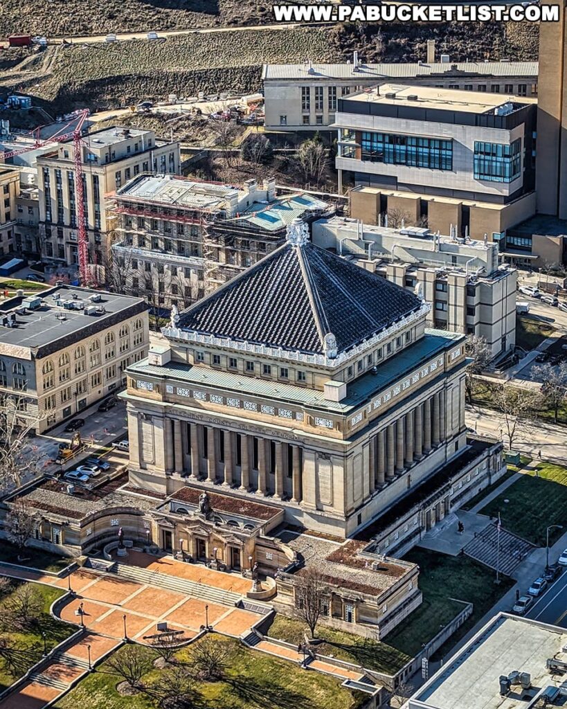 An aerial view of the Soldiers and Sailors Memorial Hall and Museum in Pittsburgh, a grand building with a prominent domed roof and stately columns, symbolizing the city's dedication to its military history. The surrounding area features well-maintained lawns, pathways, and urban development indicative of the Oakland neighborhood. This historic structure stands in close proximity to the former site of Forbes Field, linking the city's sports heritage with its commemorative landmarks. The photo captures the intersection of civic pride and remembrance in a district renowned for its contributions to both the cultural and athletic narratives of Pittsburgh.