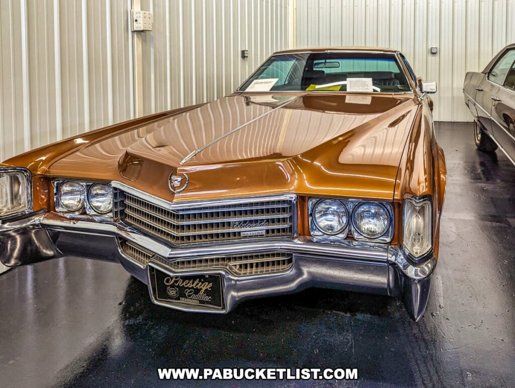 A 1970 Cadillac Eldorado with a distinctive bronze exterior on display at the Greenberg Cadillac Museum in Jefferson County, PA. The car features the classic, bold grille and sleek design characteristic of this era. It is presented in a well-maintained museum environment with other vintage Cadillacs visible in the background, emphasizing the museum's extensive and meticulously curated collection.