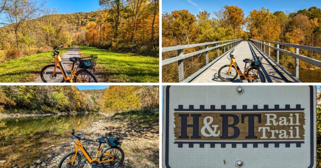A collage of four scenic photos taken along the Huntingdon and Broad Top Rail Trail in Bedford County, Pennsylvania. The top-left photo features a bright orange bicycle parked along a crushed-stone path surrounded by colorful autumn foliage. The top-right image shows the same bike on a bridge with vibrant fall trees and a view of the Raystown Branch of the Juniata River below. The bottom-left photo captures the bicycle beside the calm riverbank, with golden trees reflecting in the water. The bottom-right image highlights the H&BT Rail Trail sign, marking the historic rail trail’s location. Each image showcases the beauty of the trail during fall.