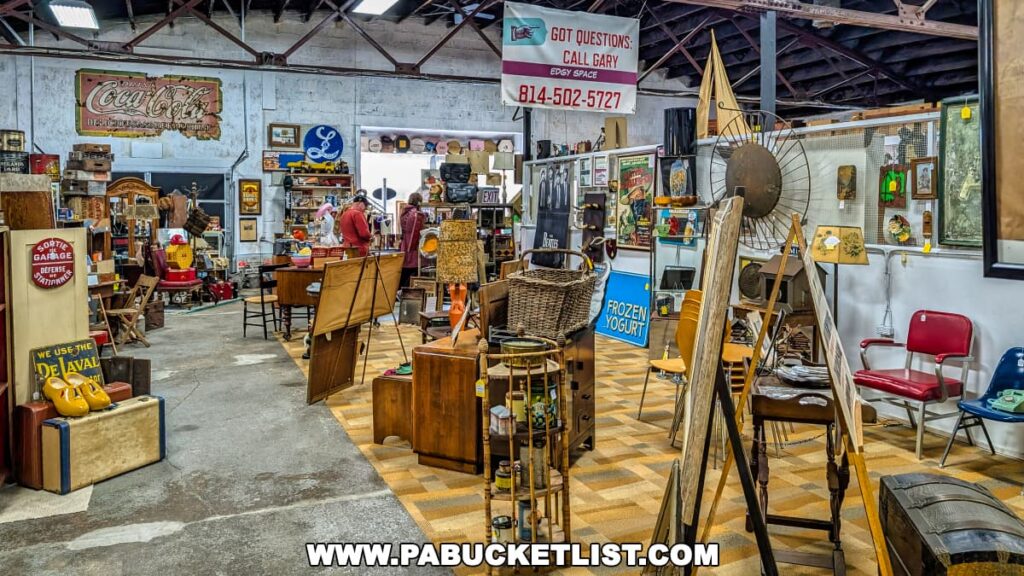 Interior view of the Duncansville Antiques Co-Op in Blair County, Pennsylvania, featuring a wide variety of antiques and collectibles, including vintage signs, furniture, artwork, decorative household items, and assorted memorabilia arranged neatly within vendor booths.