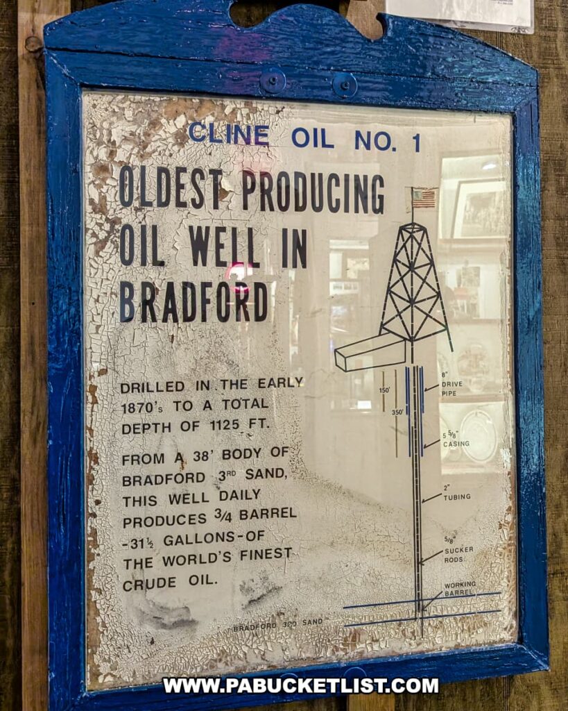 An informational sign at the Penn Brad Oil Museum in McKean County, Pennsylvania, describing Cline Oil No. 1 as the oldest producing oil well in Bradford; the sign details that the well was drilled in the early 1870s to a depth of 1,125 feet into Bradford Third Sand, producing three-quarters of a barrel, or 31½ gallons, of crude oil daily, and includes a simple diagram of the well's structure alongside text with a weathered and cracked paint appearance.