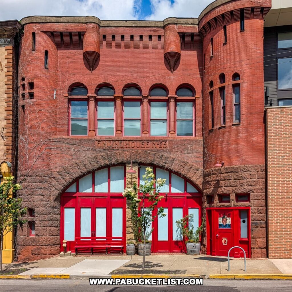 Historic red-brick firehouse with arched windows and doors, now home to the Roberto Clemente Museum in Pittsburgh, PA, featuring bold red entryways, a castle-like turret, and “Engine House No. 25” engraved above the main arch.