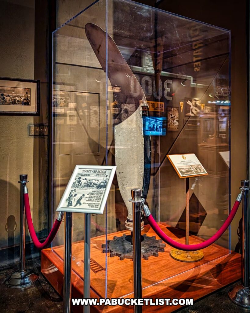 Propeller from the ill-fated plane crash that claimed Roberto Clemente’s life, displayed in a glass case at the Roberto Clemente Museum in Pittsburgh, PA, accompanied by informational panels and roped-off for preservation, serving as a solemn tribute to Clemente’s final humanitarian mission.