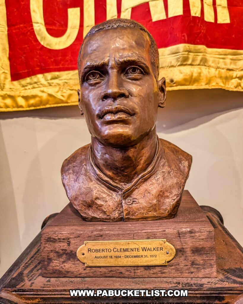 Bronze bust of Roberto Clemente displayed at the Roberto Clemente Museum in Pittsburgh, PA, featuring a nameplate with his full name and birth and death dates, modeled after the Hall of Fame sculpture honoring the legendary baseball player and humanitarian.
