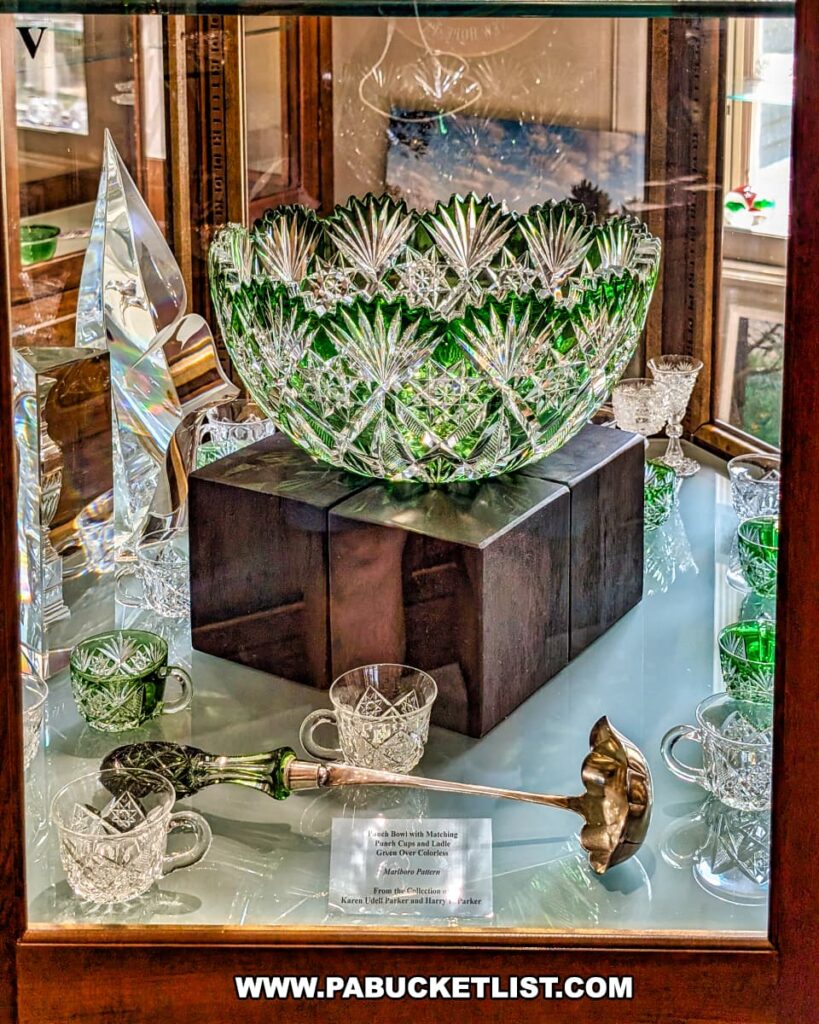 Green and clear cut-glass punch bowl with matching cups and ladle displayed in a glass case at the Dorflinger Glass Museum in Wayne County, PA